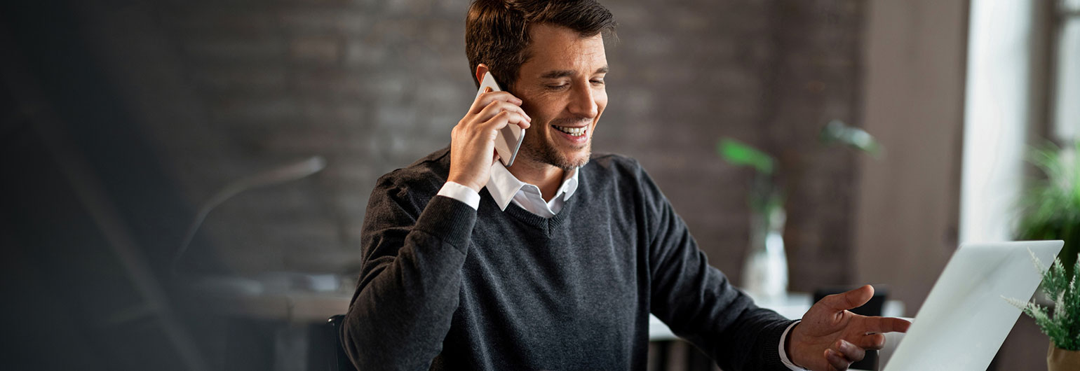 Man on the phone using a laptop